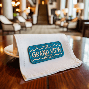 A crisp white linen napkin embroidered with a custom patch.
